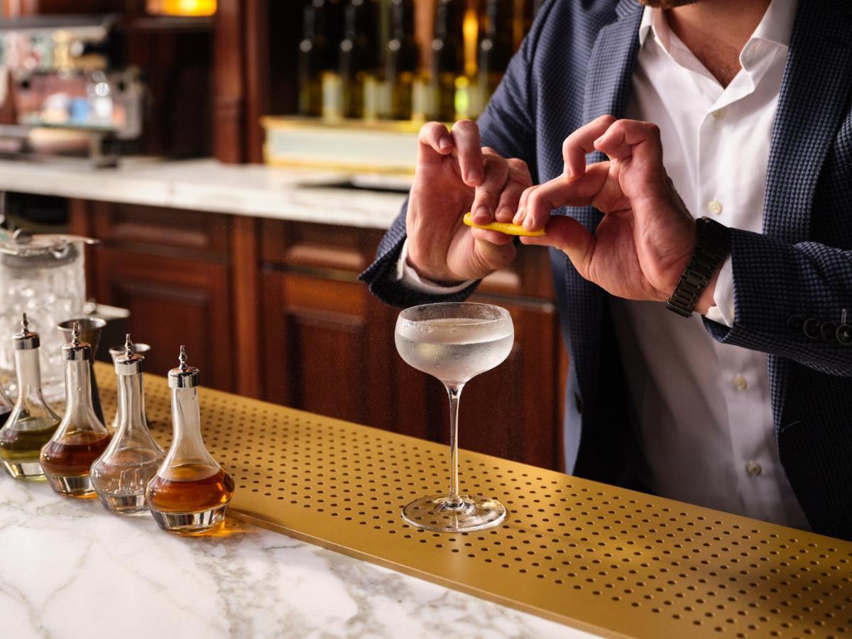 Nomad London Hotel Bagian luar foto A bartender adding a lemon twist to a Vesper cocktail